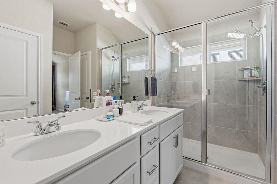 Bathroom featuring double vanity and a stall shower Bathroom featuring double vanity and a stall shower