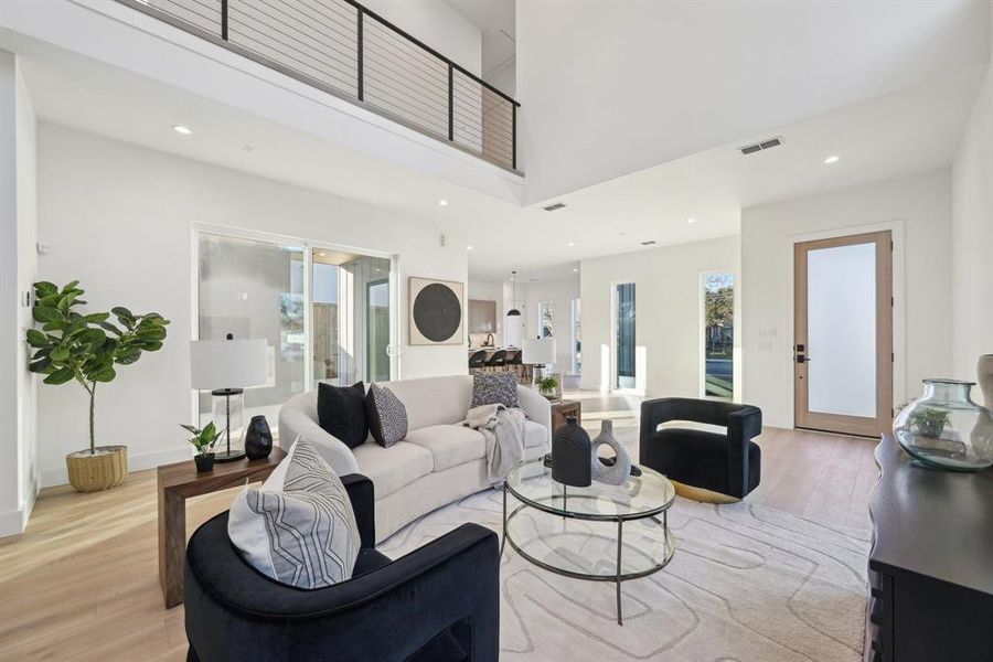 Living room featuring a towering ceiling and light wood-type flooring