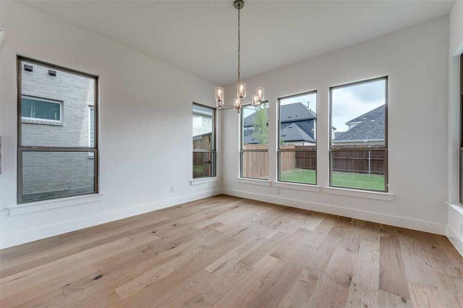 Unfurnished dining area with light hardwood / wood-style flooring and a chandelier