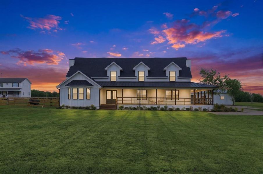 This property features a white exterior with a dark roof and dormer windows, complemented by a welcoming covered front porch This property features a white exterior with a dark roof and dormer windows, complemented by a welcoming covered front porch