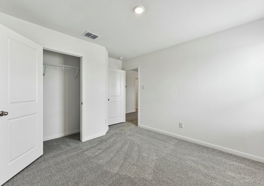 Secondary bedroom featuring carpet flooring and a closet doorway.
