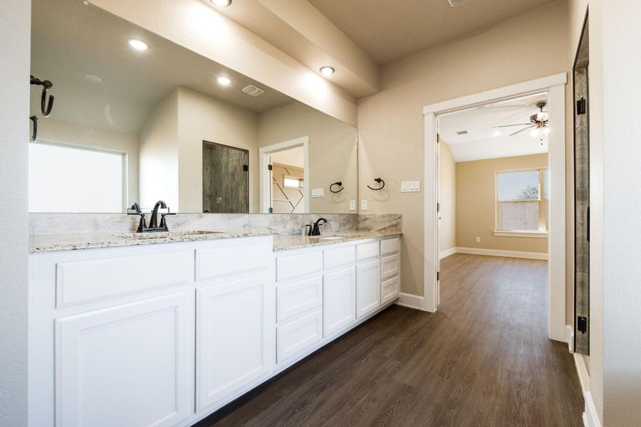 Full bathroom featuring double vanity, dark wood finished floors, a shower stall, ceiling fan, and recessed lighting
