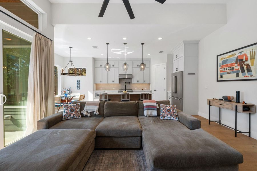 Living room with dark wood finished floors, recessed lighting, and a ceiling fan