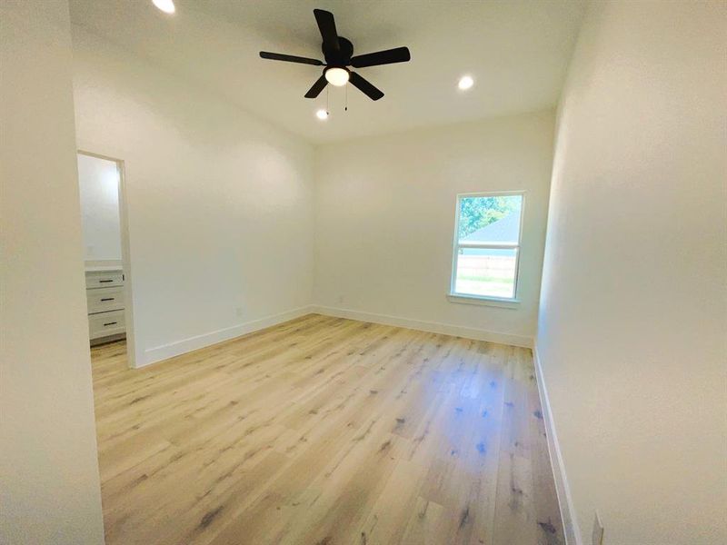 Empty room with light hardwood / wood-style floors and ceiling fan