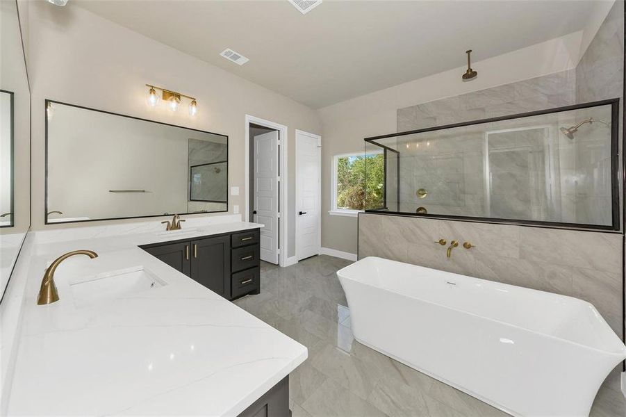 Full bathroom featuring a stall shower, vanity, and a freestanding bath