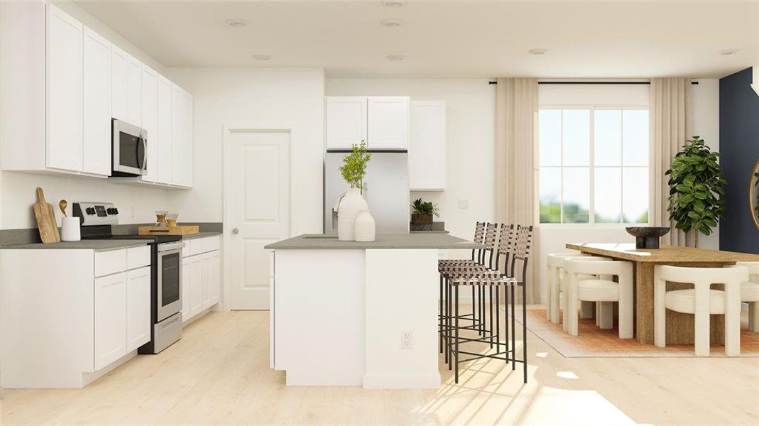 Kitchen with appliances with stainless steel finishes, a breakfast bar, white cabinets, recessed lighting, and light wood-type flooring