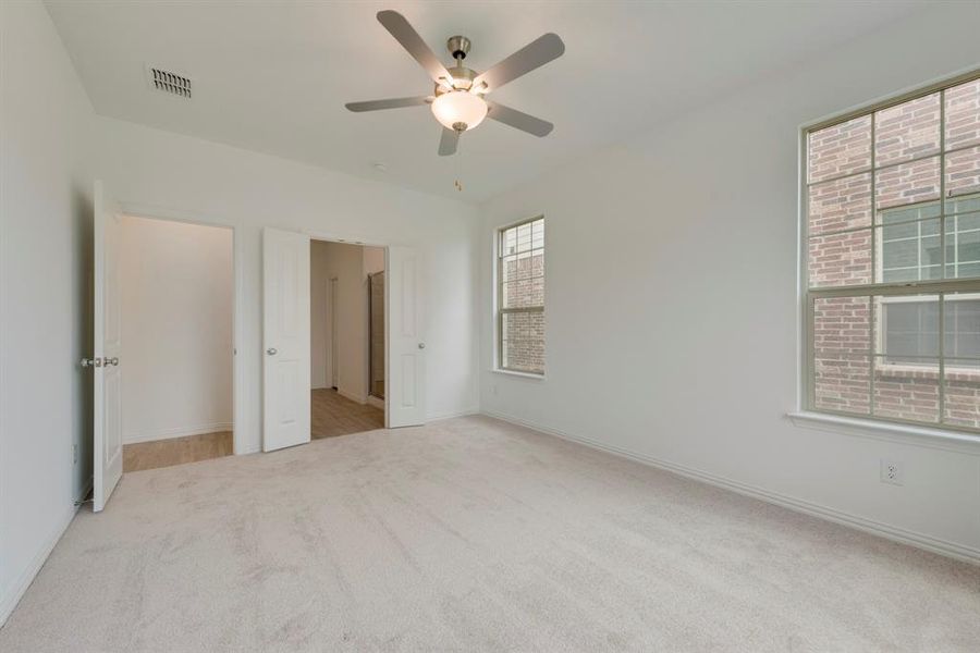 Unfurnished bedroom featuring light carpet and ceiling fan