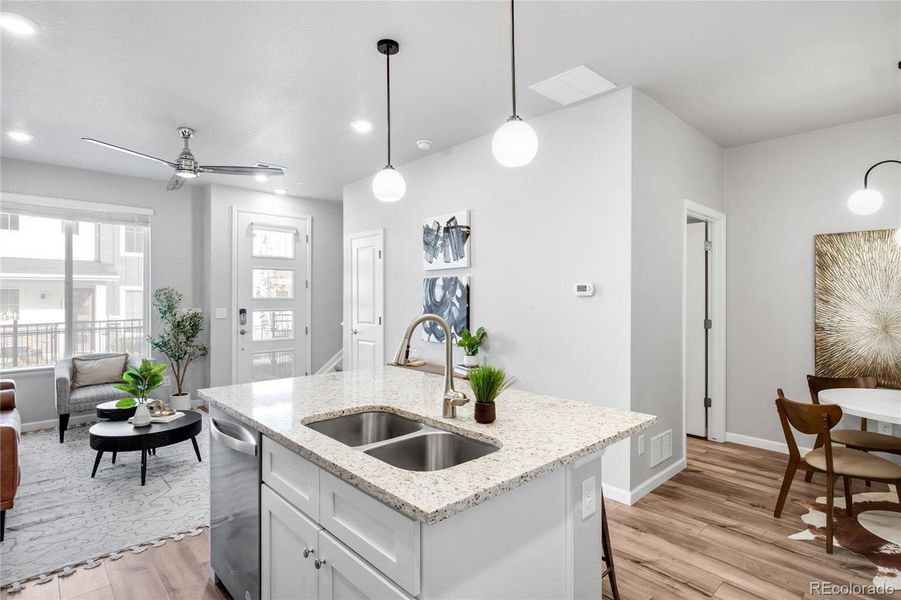 A powder room is positioned behind the stairs, beside the dining area