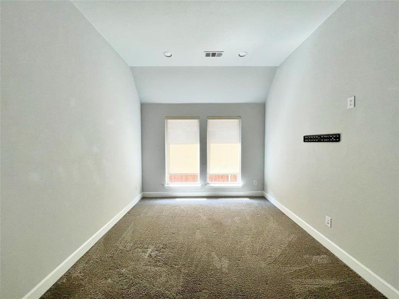 Carpeted empty room featuring lofted ceiling and recessed lighting Carpeted empty room featuring lofted ceiling and recessed lighting