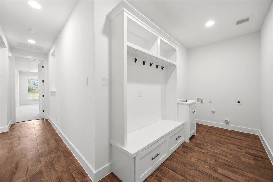 Entryway featuring a built-in mudroom bench with drawers, open shelving, and coat hooks Entryway featuring a built-in mudroom bench with drawers, open shelving, and coat hooks