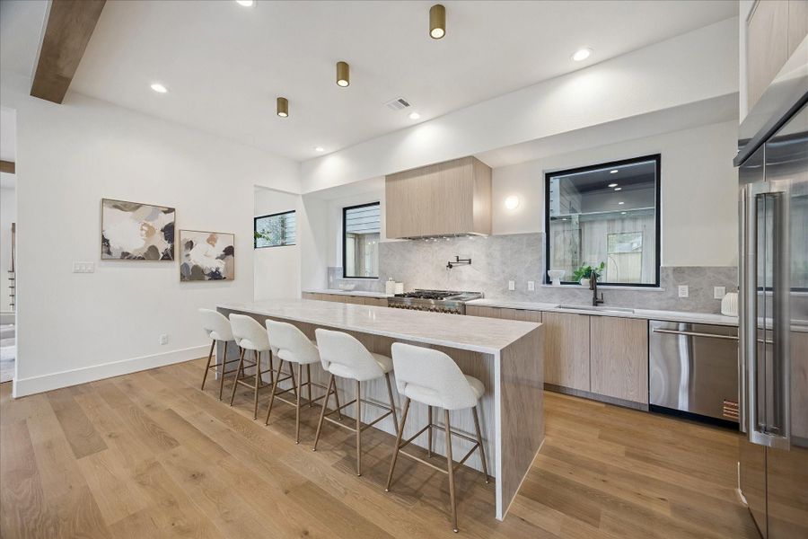 Kitchen – offers a Taj Mahal quartz double waterfall-edge seating island and stainless steel appliance package. Kitchen – offers a Taj Mahal quartz double waterfall-edge seating island and stainless steel appliance package.