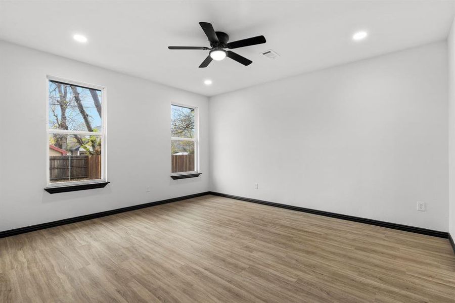 Master bedroom with light hardwood / wood-style floors and ceiling fan