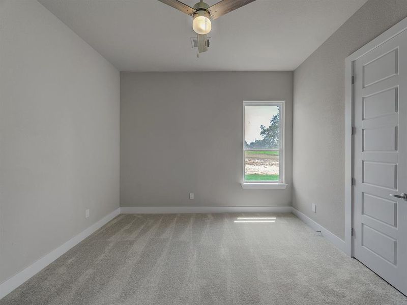 Carpeted spare room featuring baseboards and a ceiling fan Carpeted spare room featuring baseboards and a ceiling fan