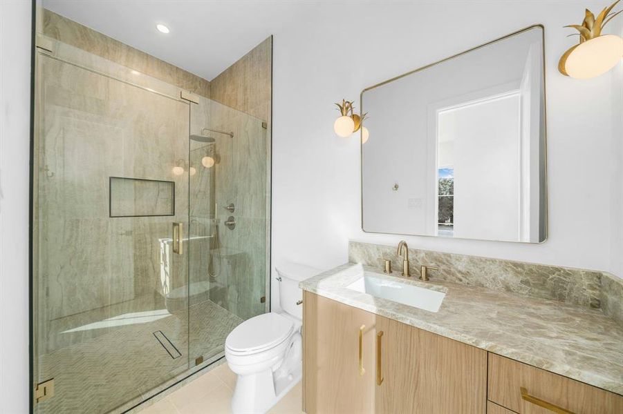 Full bath featuring vanity, a stall shower, light tile patterned flooring, and recessed lighting