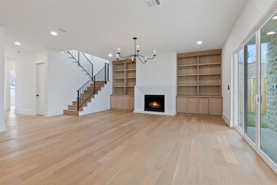 The family room exudes sophistication with custom shelves and a custom plaster fireplace that complements the kitchen’s design.