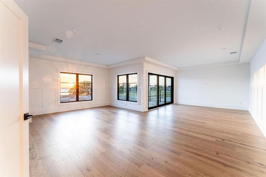 Spare room featuring light wood-type flooring and crown molding