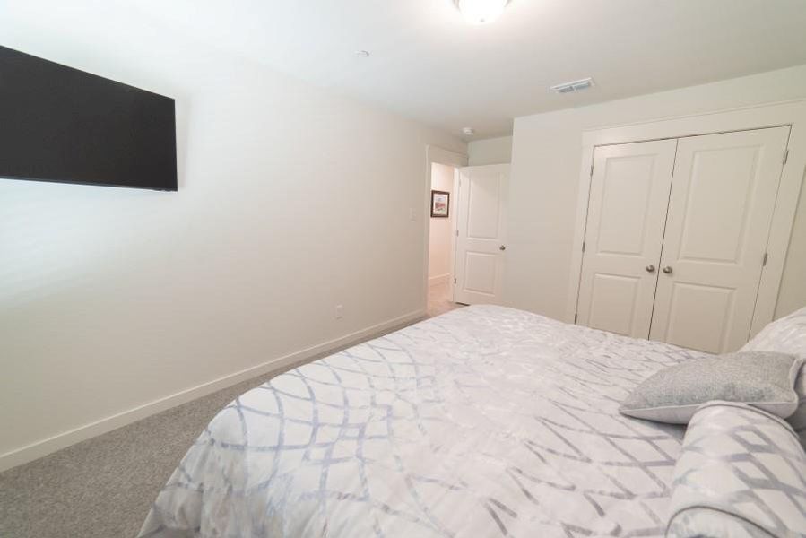 Carpeted bedroom with baseboards and a closet