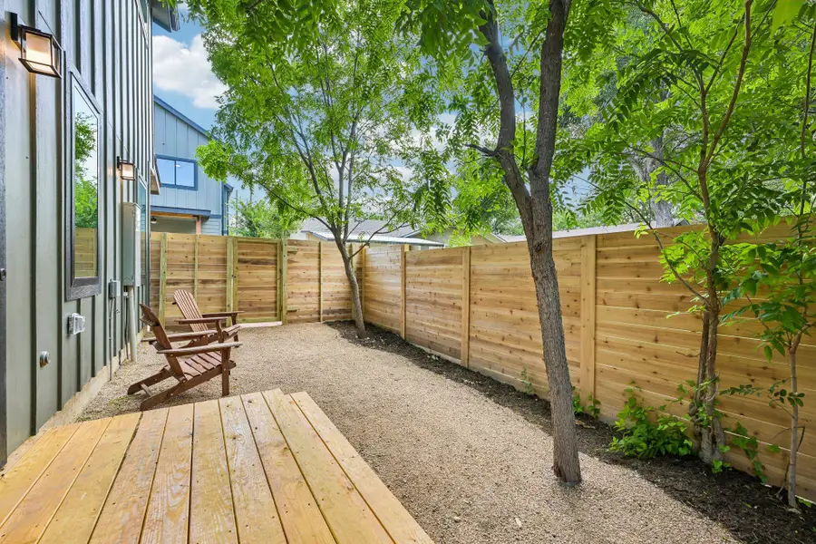 A private side yard offers a serene outdoor escape with a sturdy wood deck and tall privacy fencing. A private side yard offers a serene outdoor escape with a sturdy wood deck and tall privacy fencing.