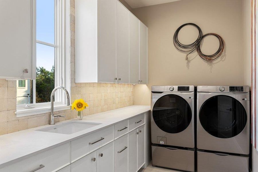 Laundry room featuring washing machine and clothes dryer and cabinet space