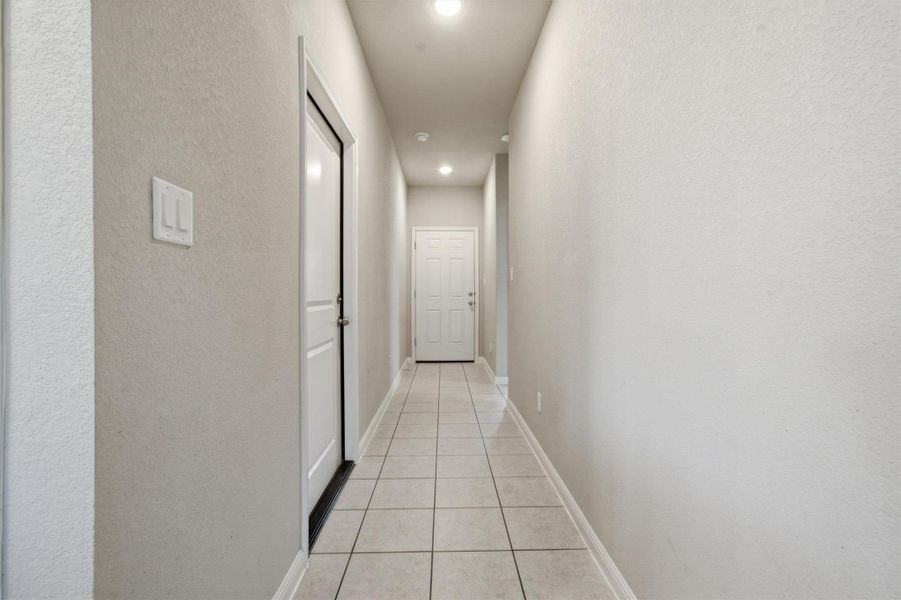 An inviting passage features sleek tile flooring and ample recessed lighting.