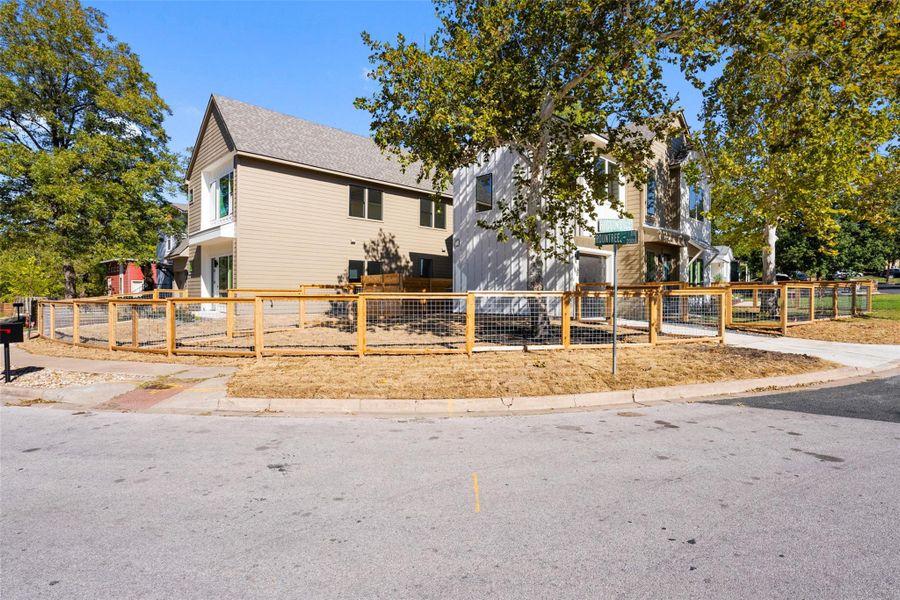 View of front of home with a fenced front yard and a shingled roof View of front of home with a fenced front yard and a shingled roof