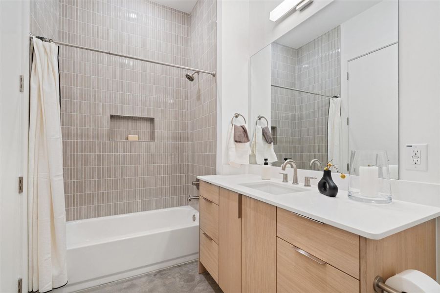 Bathroom featuring vanity and shower / bathtub combination with curtain