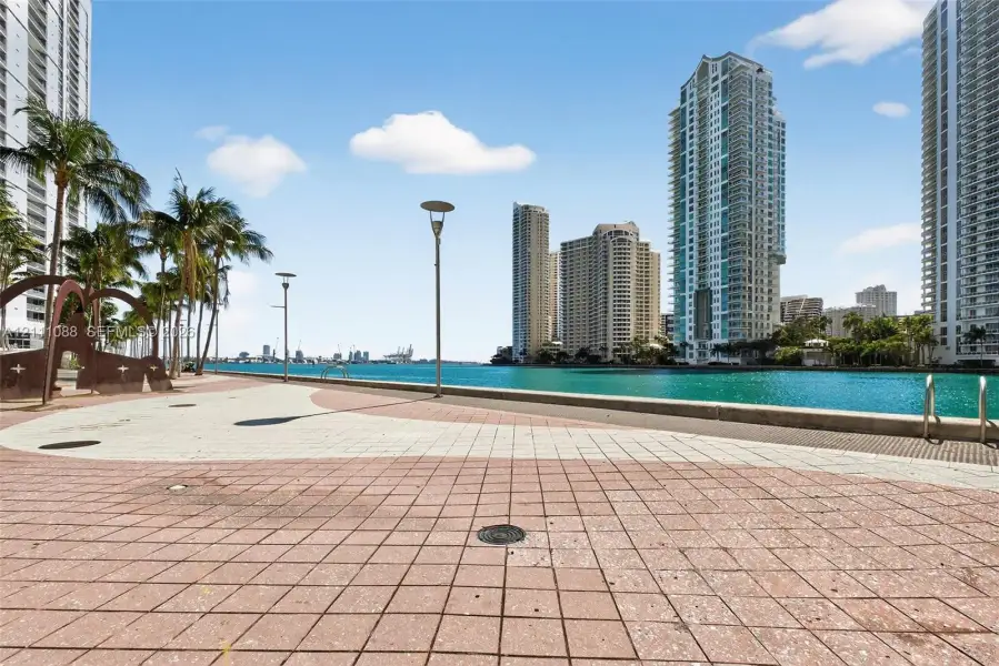 Waterfront promenade featuring paved stone tiling, custom metal sculptures, integrated exterior lighting, and direct access to the waterway Waterfront promenade featuring paved stone tiling, custom metal sculptures, integrated exterior lighting, and direct access to the waterway