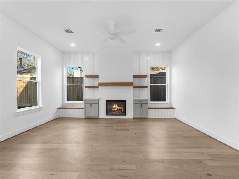 Living room with plastered electrical  fireplace built ins and benches under windows