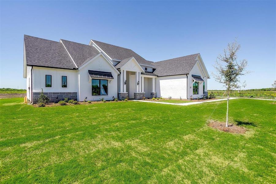 Modern farmhouse style home featuring central air condition unit and a front yard