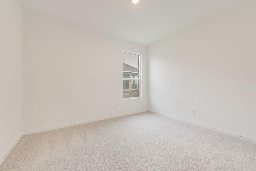 Empty room with light colored carpet and recessed lighting