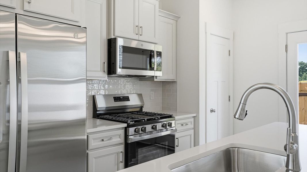 Luxury-inspired kitchen featuring expansive prep space and elegant design elements by DRB Homes