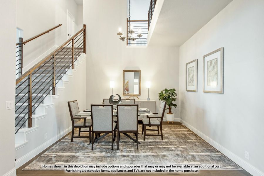 Dining room with high ceilings, six-seat table, chandelier, and staircase with metal railing nearby