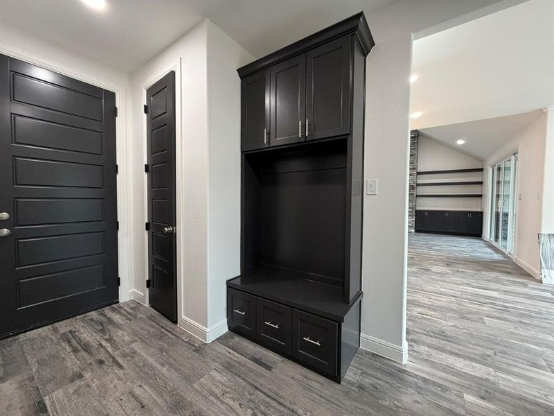 Built-in dark cabinetry with crown molding and bench seating