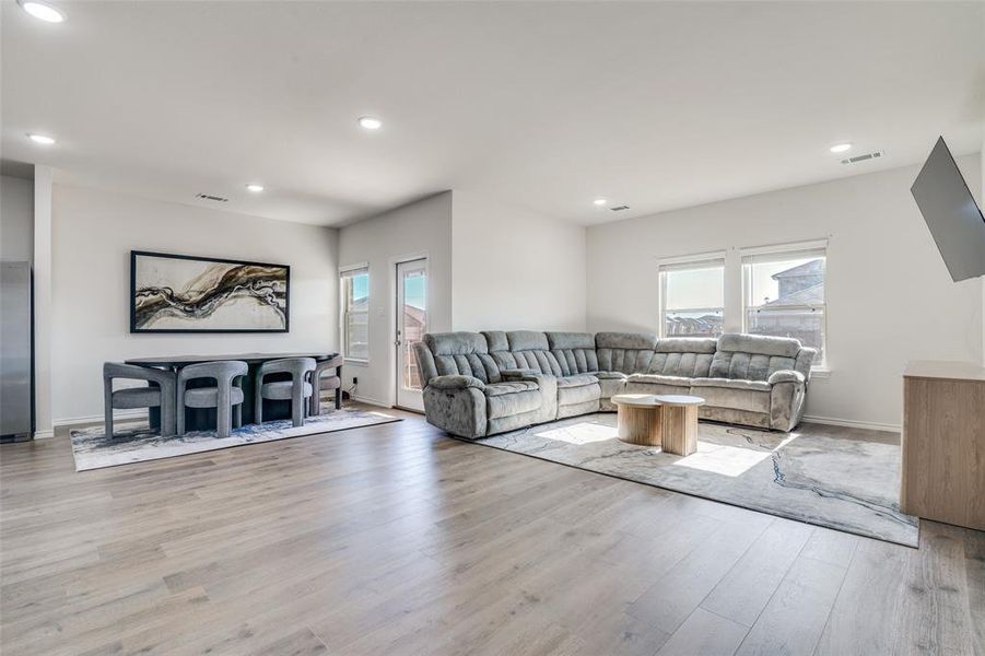 Living room featuring light wood-style flooring and recessed lighting Living room featuring light wood-style flooring and recessed lighting