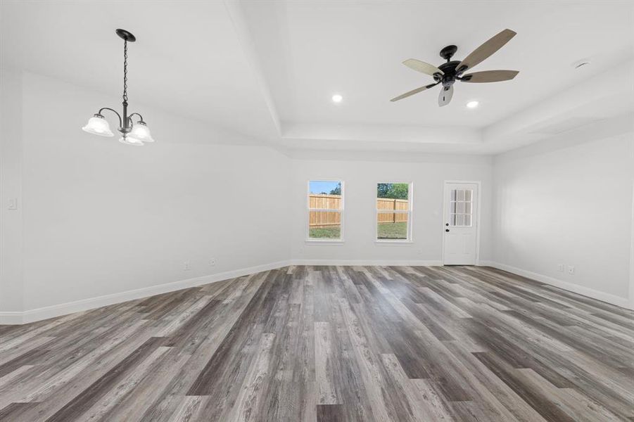 Spare room with a tray ceiling, wood finished floors, ceiling fan, and recessed lighting Spare room with a tray ceiling, wood finished floors, ceiling fan, and recessed lighting