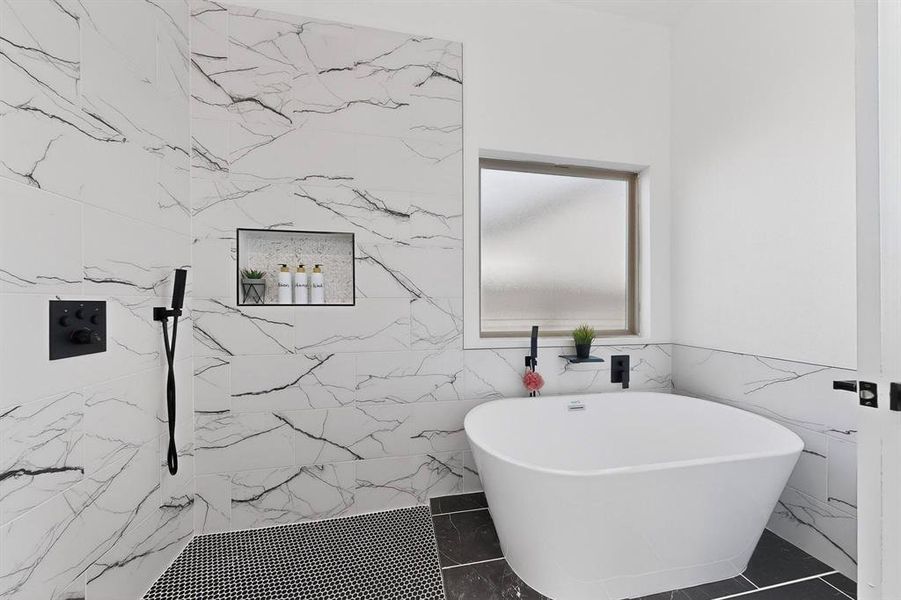 Bathroom featuring a freestanding tub, tile walls, and a marble finish shower