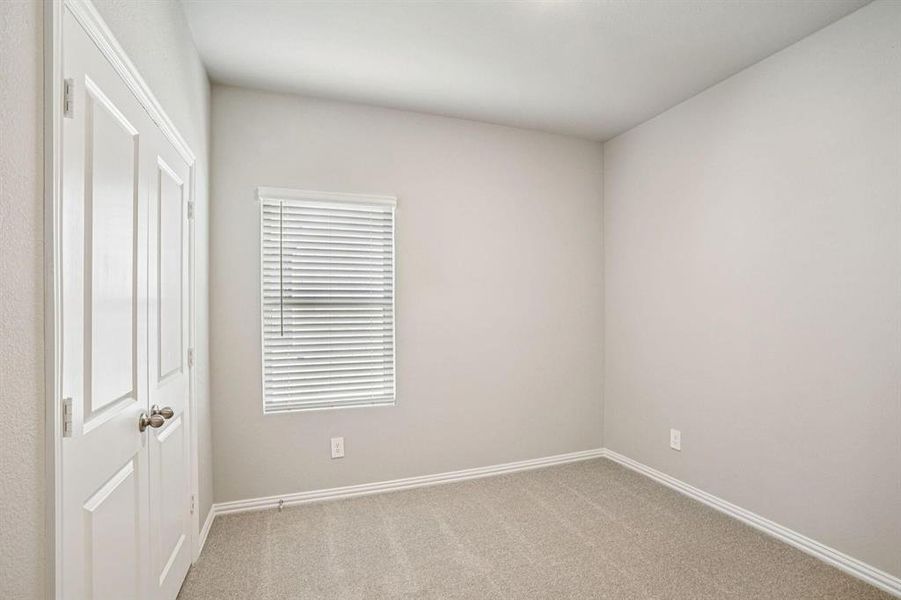 Unfurnished bedroom with carpet floors and baseboards
