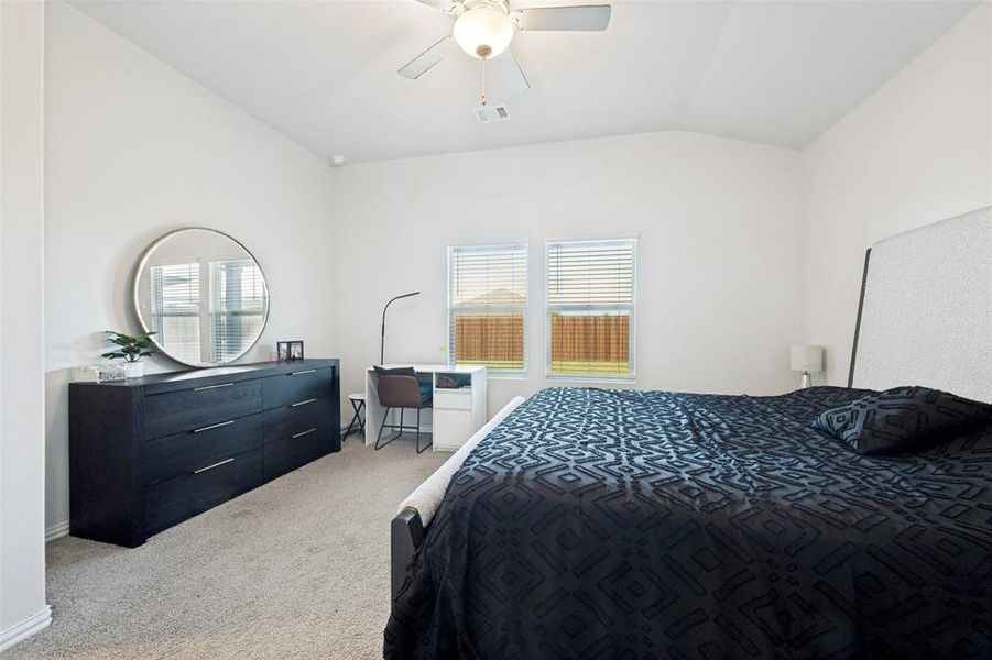 Bedroom featuring vaulted ceilings and neutral carpeting Bedroom featuring vaulted ceilings and neutral carpeting
