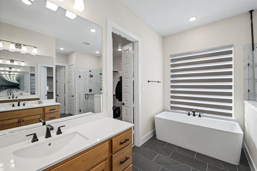 The five-piece primary bath includes a deep soaking tub, an oversized shower and two separate vanities.