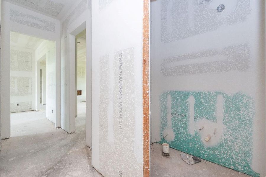 Bright and spacious under-construction home with drywall installed, showcasing potential for customization and modern finishing touches. Bright and spacious under-construction home with drywall installed, showcasing potential for customization and modern finishing touches.