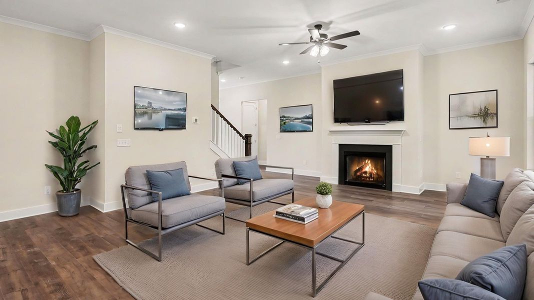 Gathering room with fireplace, ceiling fan, and hard surface flooring with furniture Gathering room with fireplace, ceiling fan, and hard surface flooring with furniture