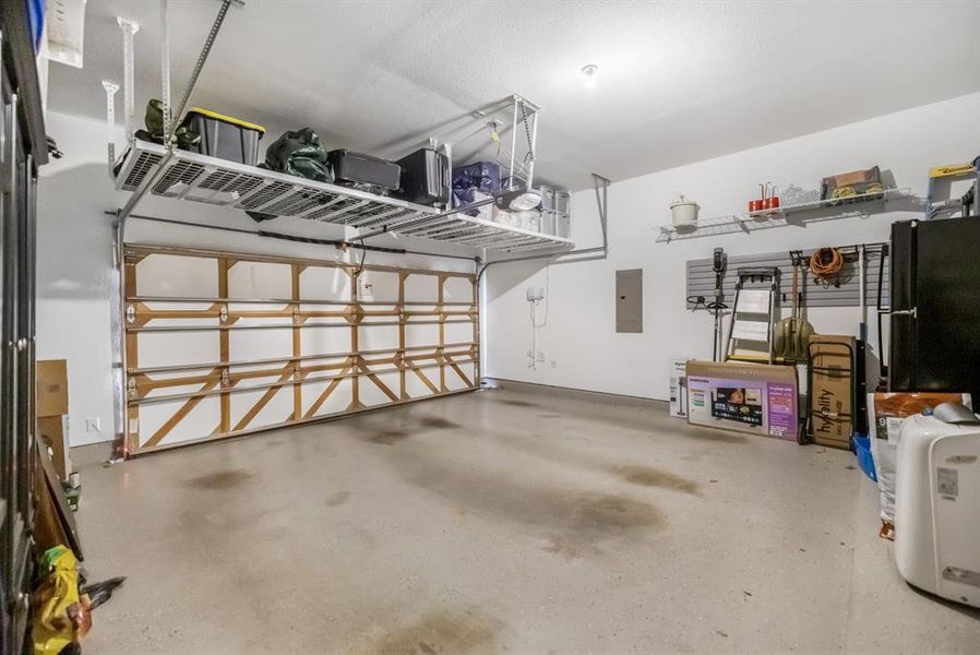 Garage with electric panel and freestanding refrigerator Garage with electric panel and freestanding refrigerator