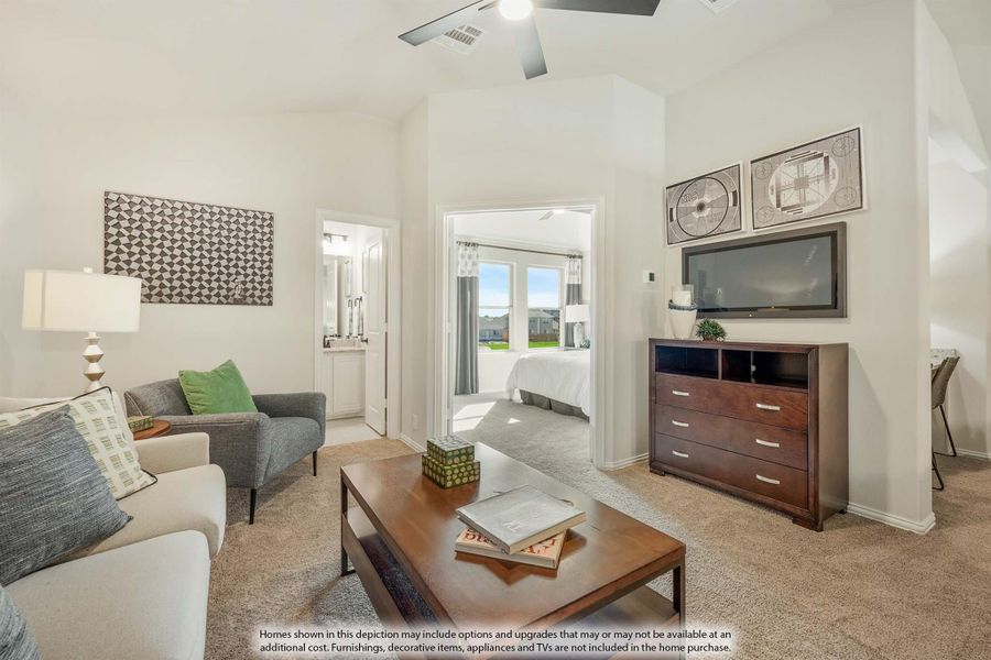Sitting area with carpet, ceiling fan, and wood dresser, open to bedroom and bathroom beyond