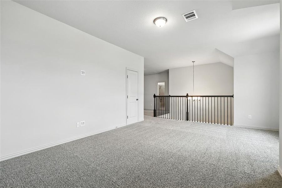 Carpeted spare room featuring baseboards
