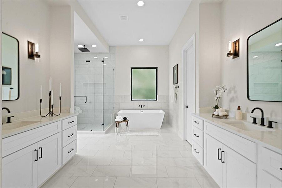 Primary bathroom with dual vanity sinks, large mirrors, a freestanding tub, and a glass-enclosed shower.