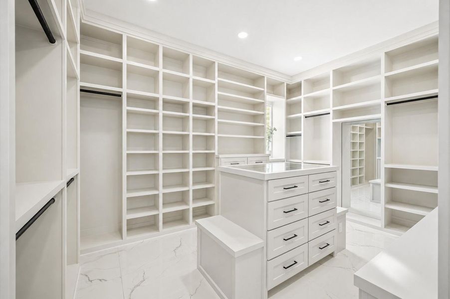 One of two oversized walk-in closets featuring custom built-in storage.