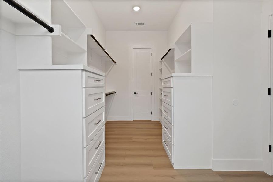 Spacious closet featuring light wood finished floors Spacious closet featuring light wood finished floors
