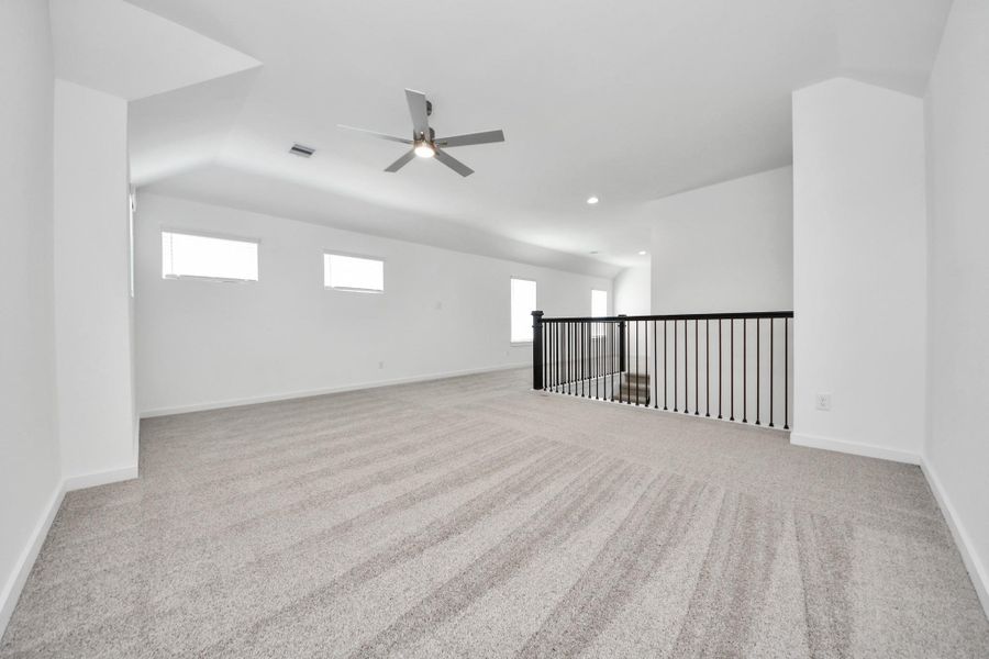 Ascend to relaxation in this fantastic game room! Ideal for both casual gatherings and adult gaming, it boasts plush carpet, lofty ceilings, custom paint, and ample windows for abundant natural light. Sample photo of completed home with similar floor plan. Actual colors and selections may vary.