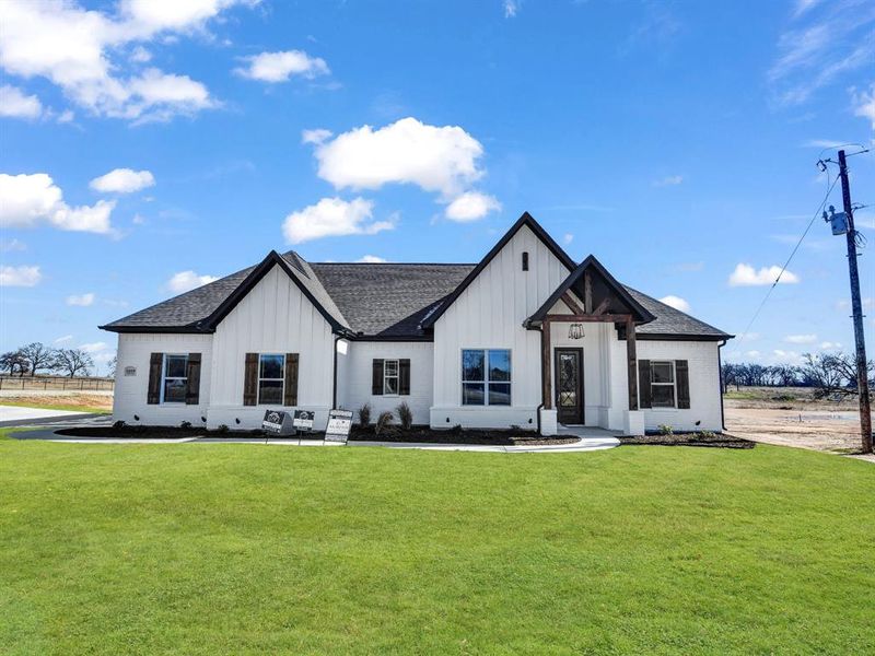 Modern farmhouse style home featuring a front yard