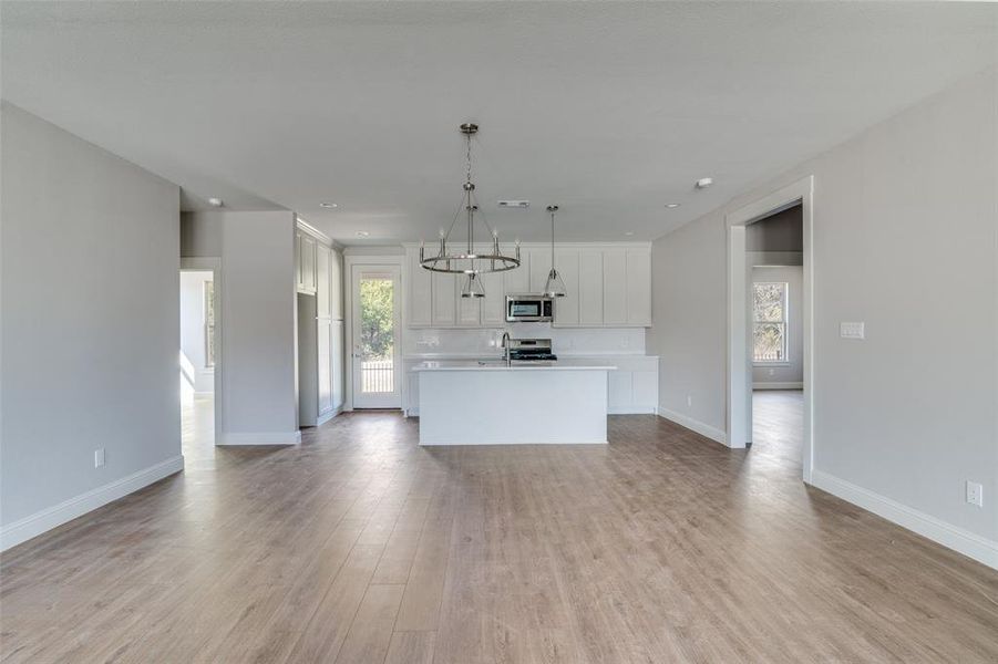 The kitchen has pendant lights over the island.